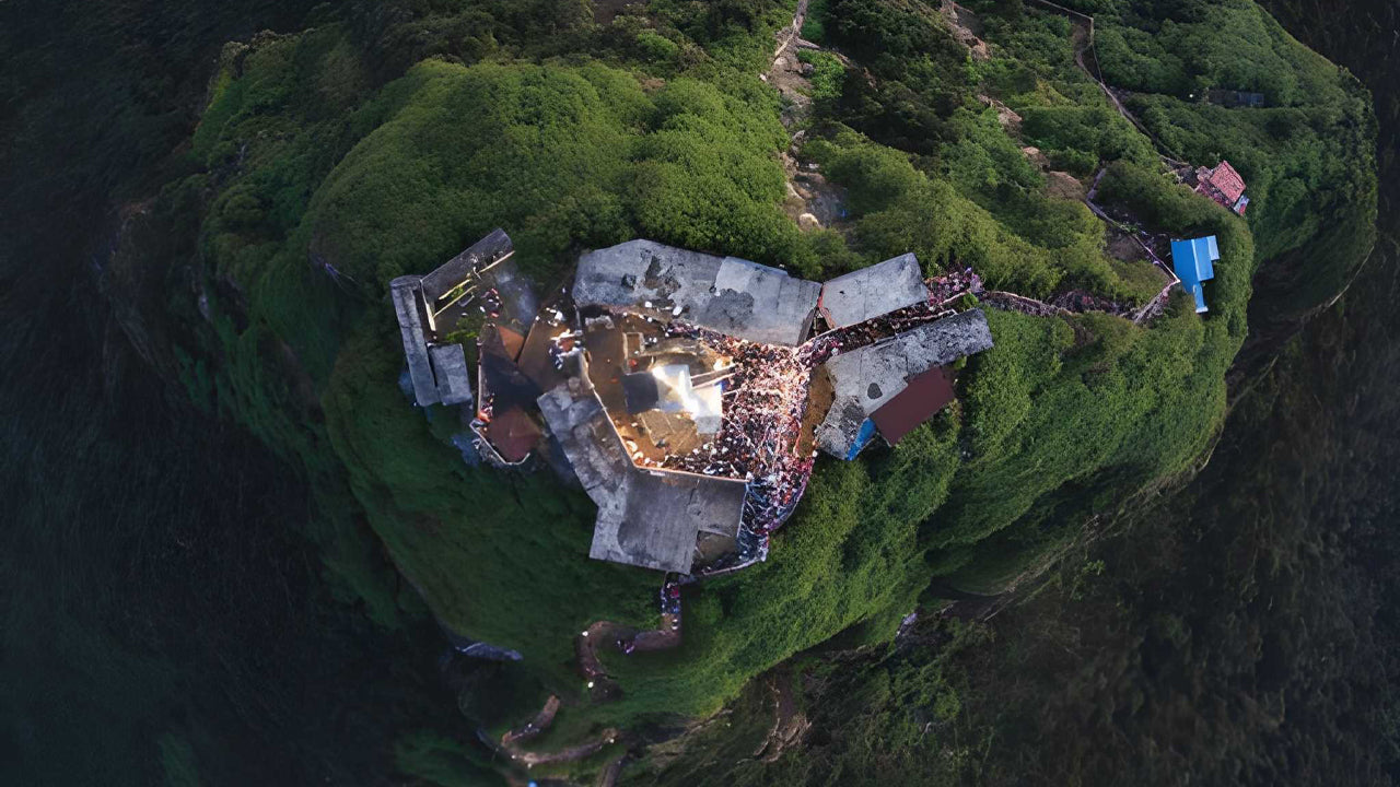 Aerial view of a mountain top with a large gathering of people and tents.
