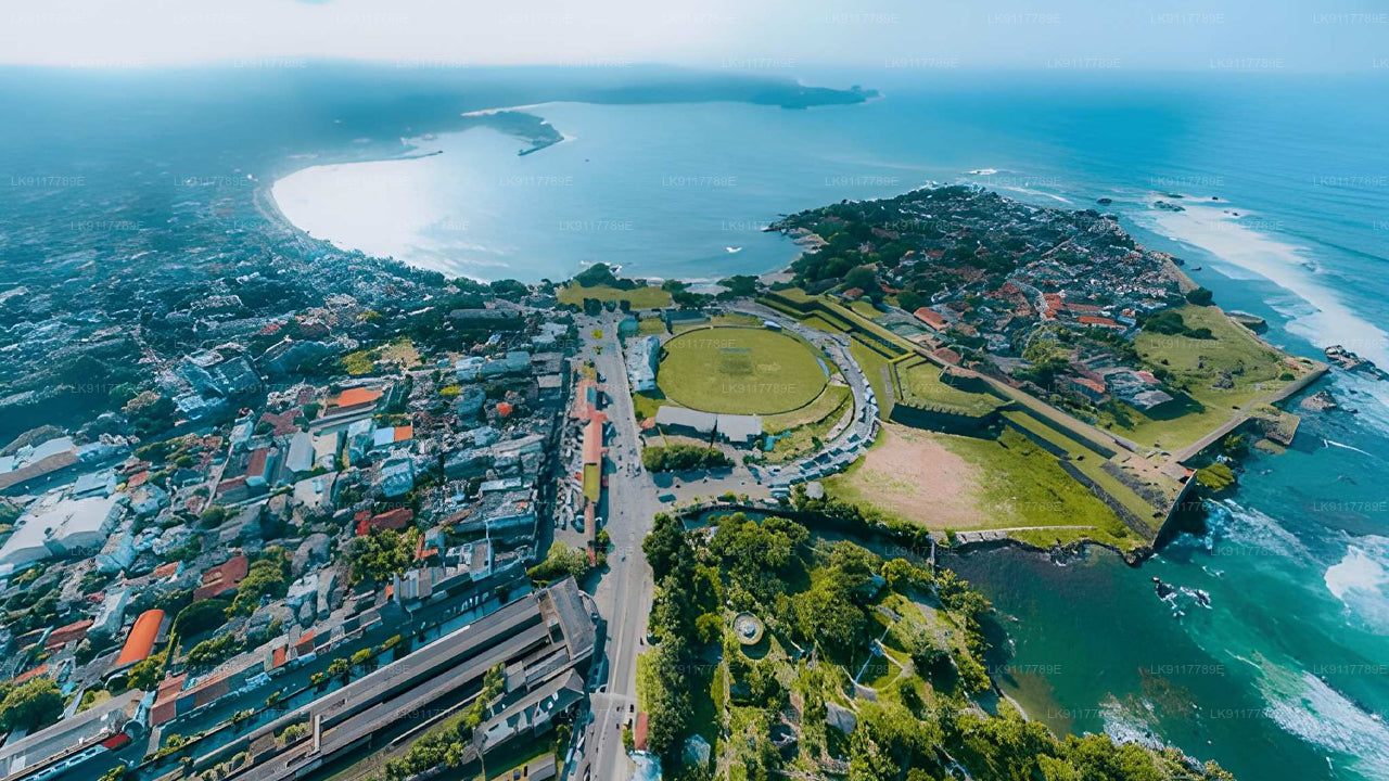 Aerial view of a coastal city with a large roundabout and waterfront.